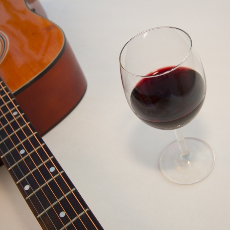 Glass of red wine and a part of acoustic guitar  White background with shadows の写真素材