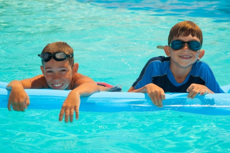 Two happy boys in the swimming pool. Blue water. Brothersの写真素材