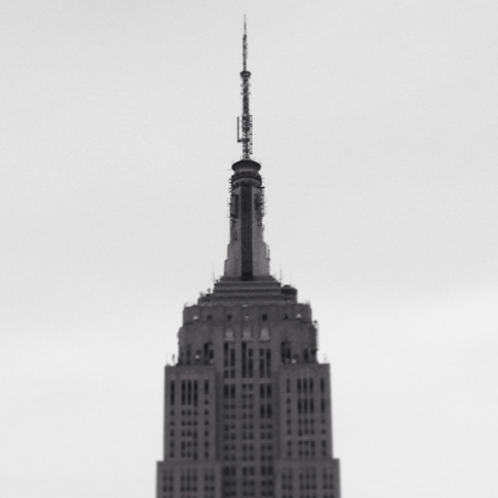 Image of the top of the Empire State Building in black and white with clear skies.のeditorial素材