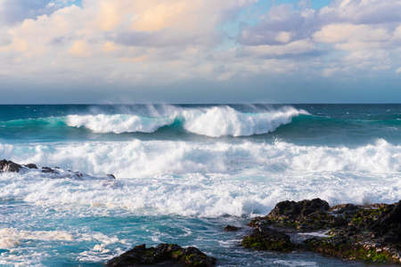 Beautiful seascape with waves breaking on the rocky shore.