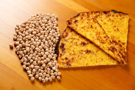 Typical Italian Pizza cooked in electric oven with ingredients in the background on a wood tableの写真素材