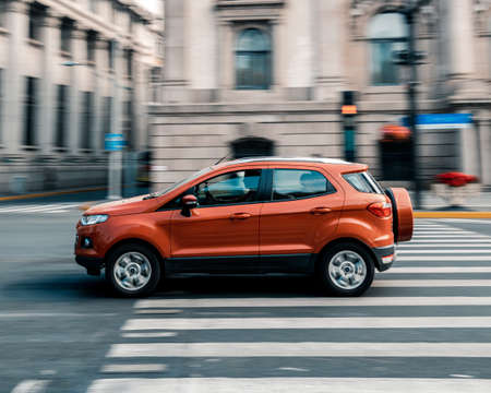 Orange SUV car speeding fast on the streets of Shanghai, China captured one shot with panning and stop motionのeditorial素材