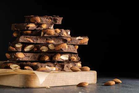 almond dark chocolate pieces tower on a wooden tableの写真素材