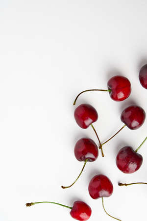 Sweet red cherries isolated on white background, fresh cherries with stems and leaves. Copy space. Food and fruit concept.の写真素材