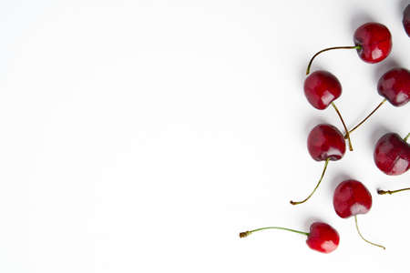 Sweet red cherries isolated on white background, fresh cherries with stems and leaves. Copy space. Food and fruit concept. Flat viewの写真素材