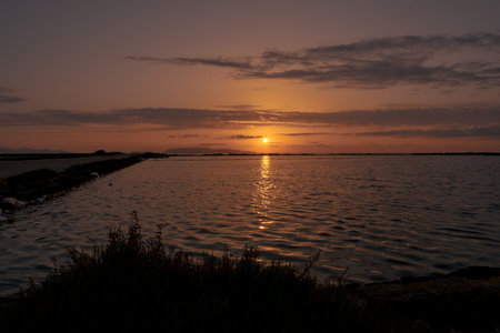 Sunset landscape of salt pans in traditional salt production in Trapani, Sicily, italy.の写真素材