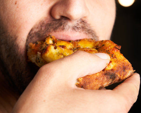 Close-up of man eating Italian pizza. Lifestyle concept.の写真素材
