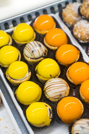 delicious cakes covered with bright orange and yellow mirror glaze. conceptual design pastry desserts.の写真素材