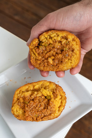 Hands showing a fried rice ball inside. Sicilian Street Foodの写真素材