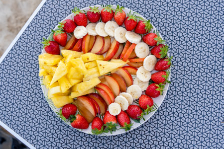Dish of healthy fresh fruit salad on table background. Top views.の写真素材