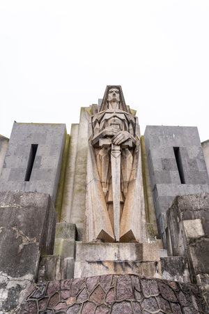 Modernist stone sculpture of an angel warrior with angular details and a sword. A striking monument symbolizing strength, resilience, and history.の写真素材