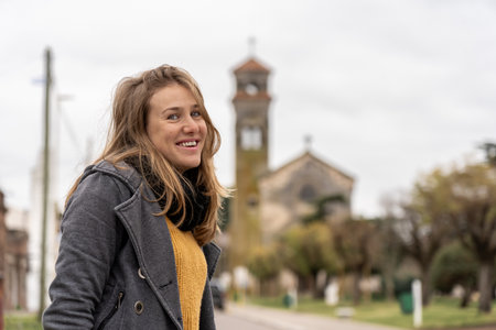 Woman smiling on street with historic church in the backgroundの写真素材