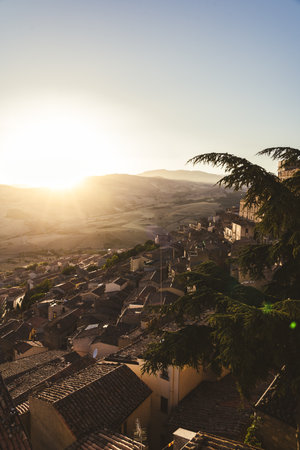 Terracotta rooftops overlooking rolling hills at sunsetの写真素材
