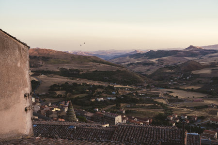 Tiled dome and rooftops overlooking Italian countryside at sunsetの写真素材