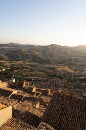Terracotta rooftops overlooking rolling hills at sunsetの写真素材
