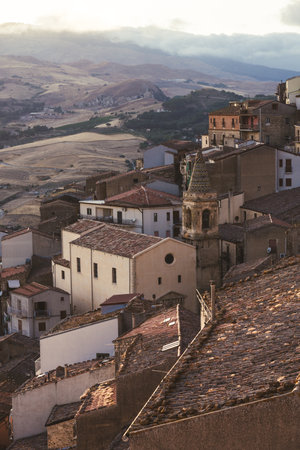 Terracotta rooftops overlooking rolling hills at sunsetの写真素材