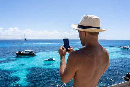 Man taking smartphone photo of boats in Favignana, Sicily