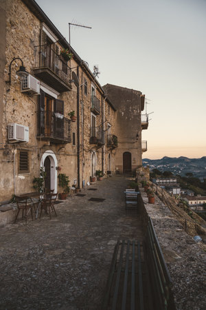 Rustic alley with stone houses and valley view in a Sicilian hilltop villageの写真素材