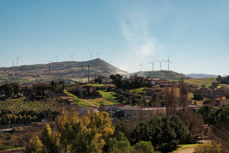 Wind turbines on hills behind a small countryside town