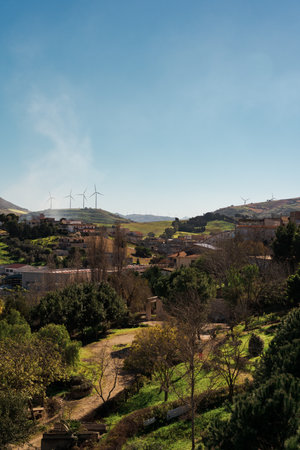 Wind turbines on hills behind a small countryside townの写真素材