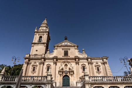 Sicilian baroque cathedral facade with bell tower and blue skyの写真素材