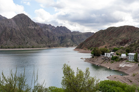 Mountain reservoir with lakeside houses under cloudy sky