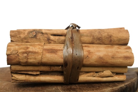 Cinnamon sticks tied in a bundle on a wooden board with text space