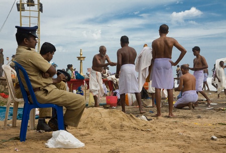 KERALA - AUGUST 9: Indian Police keep an eye on the crowds at a hindu festival on August 9, 2010 in Kerala, India. Every year, thousands come to Varkala, Kerala to commemorate the dead.のeditorial素材