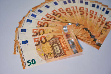 Stack of 50 Euro banknotes. European currency money banknotes over white background. Salary, savings, european union economic crisis concept.の写真素材