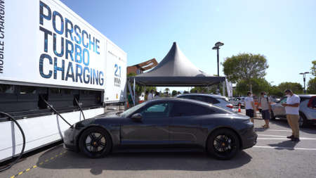 Murcia, Spain - July 17, 2021: Side of a Porsche Taycan Turbo charging at Porsche and Iberdrola Charging Station. The location is a mall in Murcia, Spain.のeditorial素材