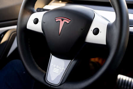 Murcia, Spain - DECEMBER 1, 2019: The insignia of Tesla on the wheel of the plug-in electric car Model 3, a mid-size / compact executive luxury four-door sedan manufactured and sold by Tesla, Inc. decorated with some white and red stickers.のeditorial素材