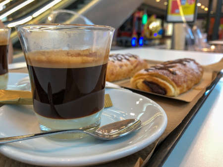 Close-up of a coffee glass and a chocolate desert in a mall.の写真素材