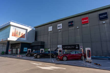 MURCIA, SPAIN - FEBRUARY 2, 2021: Three electric vehicles are parked in a Supercharger station of Tesla brand.のeditorial素材