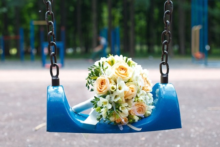Wedding bouquet on blue swing in parkの写真素材
