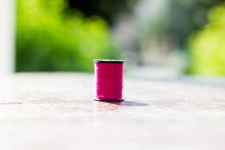 pink thread on the table, on nature backgroundの写真素材