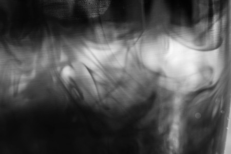 ink dissolve in a glass background abstractionの写真素材