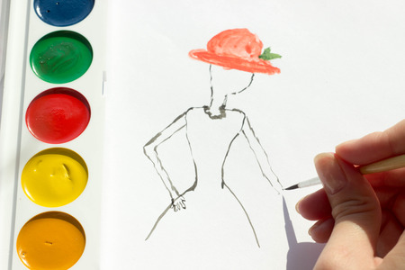 the artist teaches painting with a brush and watercolor of a woman on a conventional album sheetの写真素材