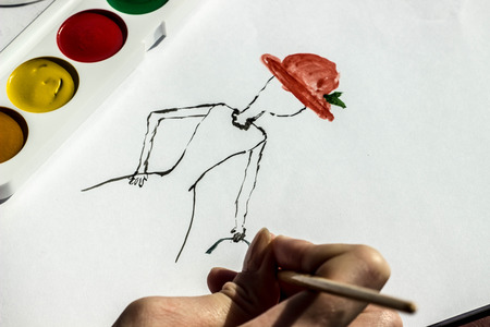 the artist teaches painting with a brush and watercolor of a woman on a conventional album sheetの写真素材