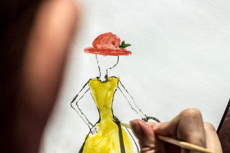 the artist teaches painting with a brush and watercolor of a woman on a conventional album sheetの写真素材