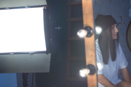 European girl against a brick wall in a t-shirt and hat fashion styleの写真素材