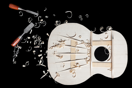 Sound top of guitar under construction with chisels and wood chipsの写真素材