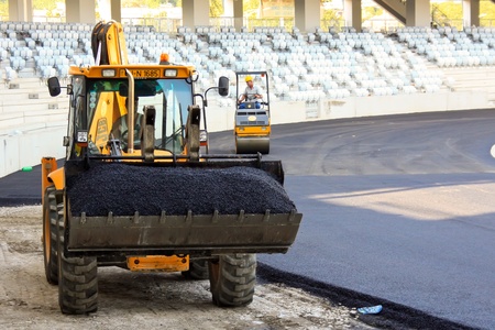 Cluj-Napoca, Romania - August 24, 2011 - Workers smoothing asphalt at Arena stadium from Cluj-Napoca