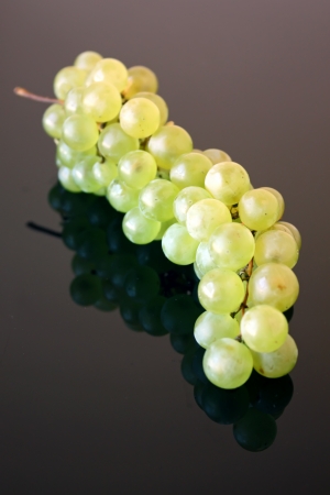 Green grape isolated over black glass backgroundの写真素材