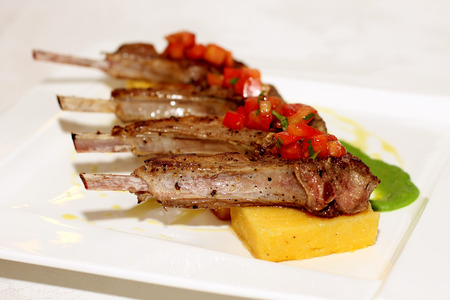 Grilled ribs with polenta on white plateの写真素材
