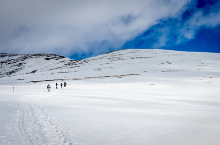 Winter landscape in the mountains. Group of hikers. Mountain ridges covered by snow in winter in...