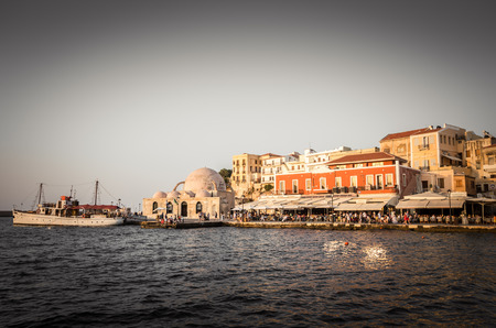 Chania town in Crete island. View of the old venetian port of Chania on Crete island, Greece. Tourists relaxing on promenade.の写真素材