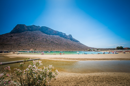 Stavros beach on Crete island, Greece. Tourists relax and bath in crystal clear water.の写真素材