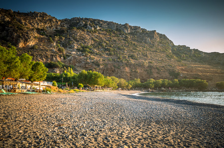 Sfinari Beach in Crete island, Greece. Straw parasols and sunbeds on the beach in twilight.の写真素材