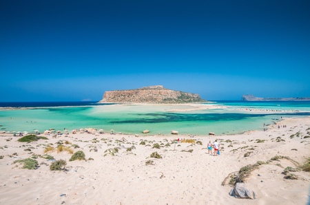 Balos lagoon on Crete island, Greece. Tourists relax and bath in crystal clear water of Balos beach.の写真素材