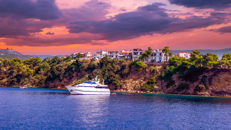 Sunset over Skiathos town, Greece. Luxury yacht in the bay of Skiathos, near the harbourの写真素材